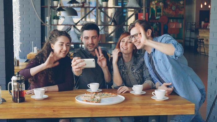 Grupo de amigos sonriendo juntos en una cafetería